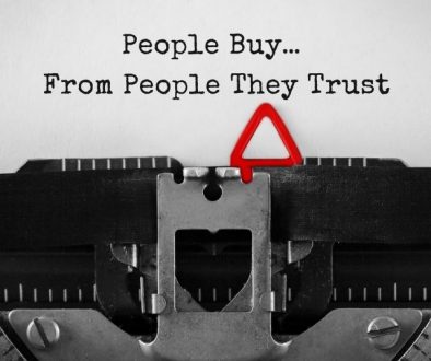 Typewriter showing "People Buy... From People They Trust" in text.