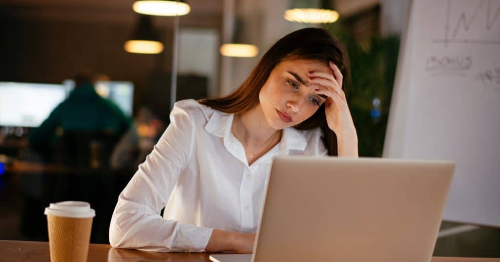 image of stressed woman at office in front of a laptop in an office