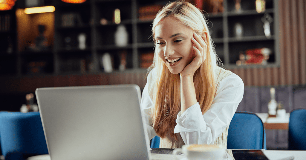 Young woman smiles at computer screen for video recording during college recruitment