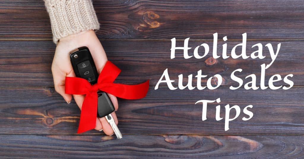 A woman extending a vehicle key with a red bow with the text "holiday auto sales tips" in white next to the key.
